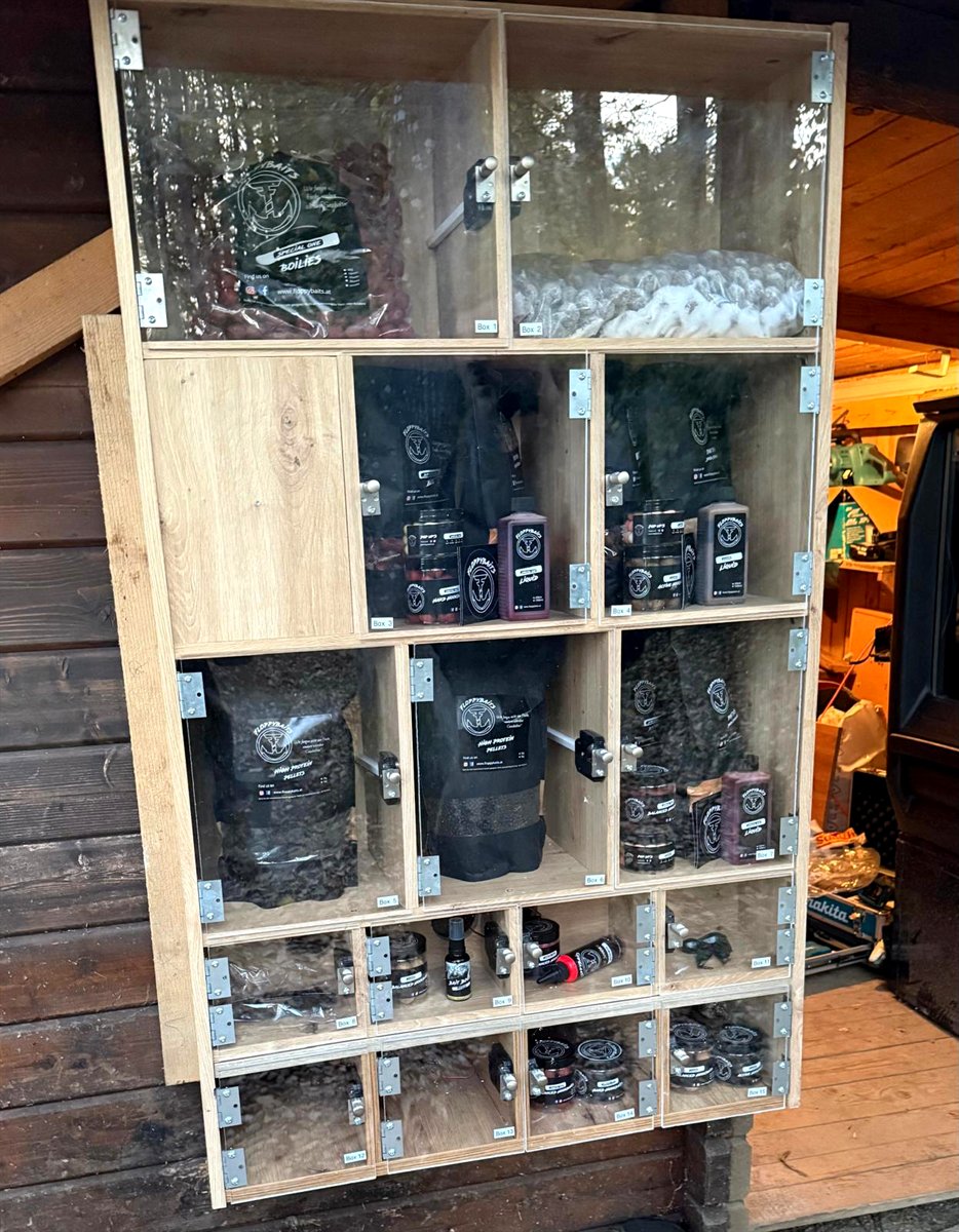 Paybox: Verkaufswand aus Holz mit einzeln verschließbaren Fächern voller Ware